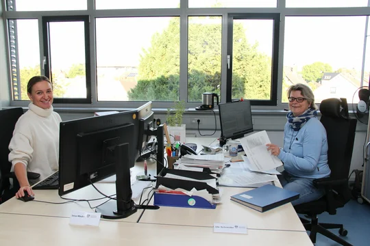 Zwei Frauen vom Bürgerservice sitzen im Büro vor ihren Computern.